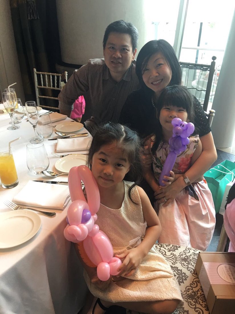 Family with balloon sculptures at a restaurant party