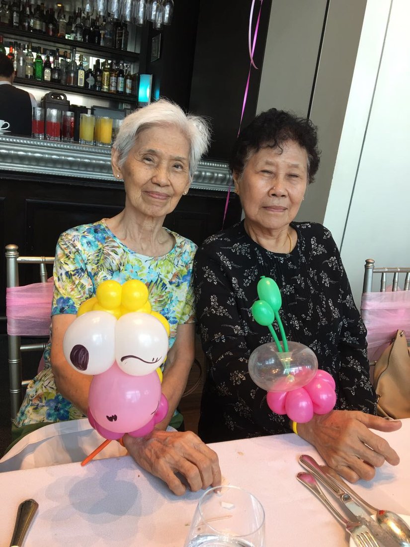 Grannies enjoying balloon sculptures at a party